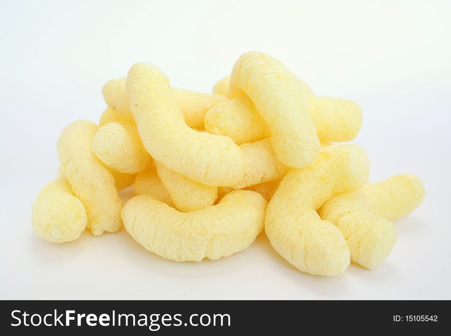 A few yellow, crunchy corn snacks on white background