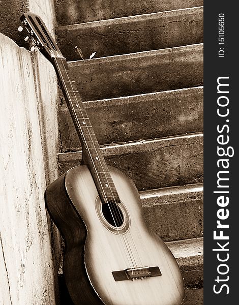 Sepia image of guitar near steps