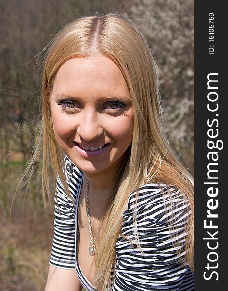 Blond girl in front of blossomed tree on early spring