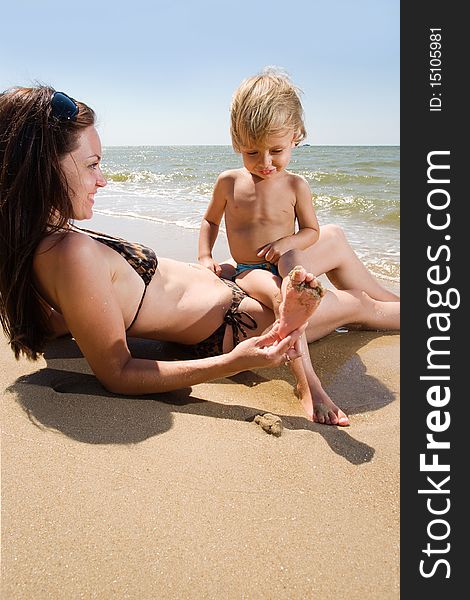 Young mother having fun with her son at the sea