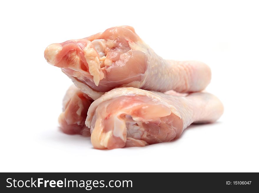 Close up of three raw chicken drumsticks isolated on white background.