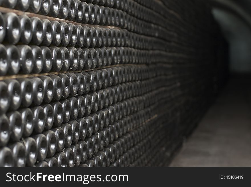 Tunnel with old aged wine in dusted bottles. Winemaking plant.