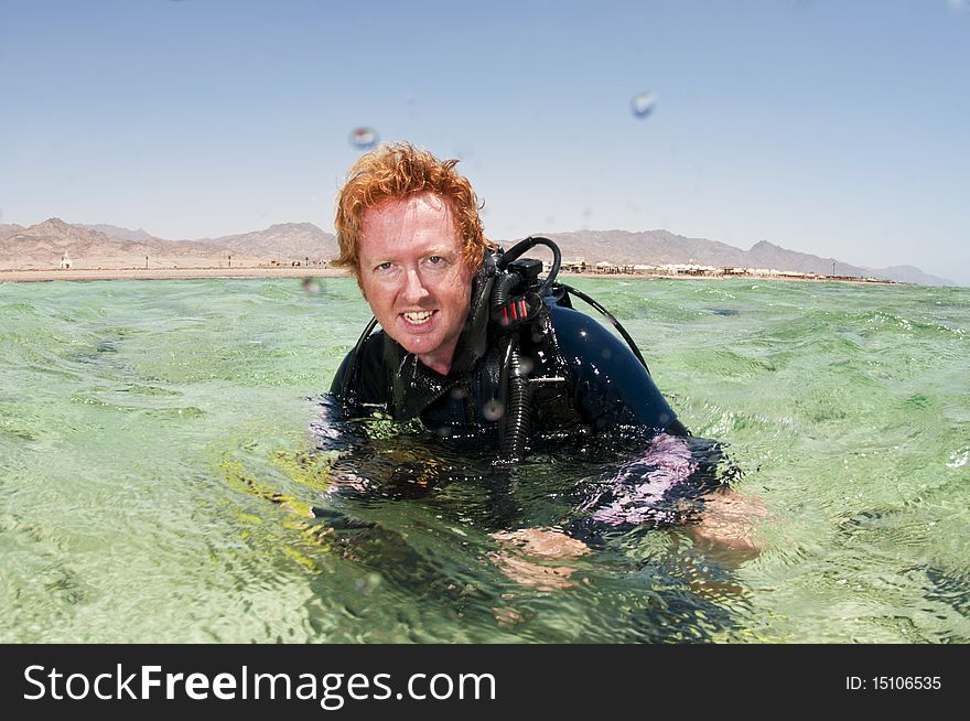 Male scuba diver on surface in red sea