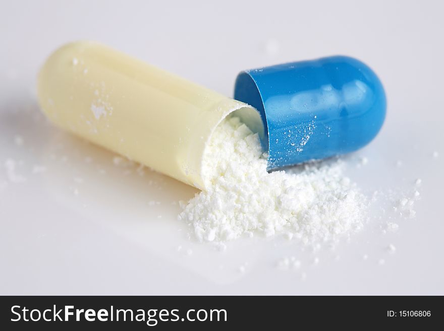 Close up of pill peeled into half with powder isolated on white background. Close up of pill peeled into half with powder isolated on white background