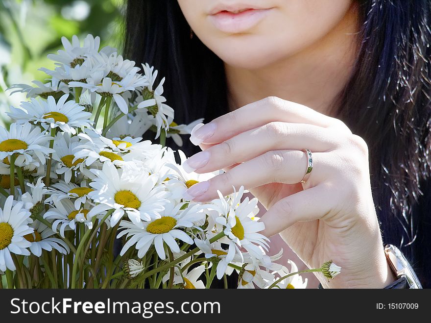 A girl holds in a hand a bouquet and tears away a petal. A girl holds in a hand a bouquet and tears away a petal