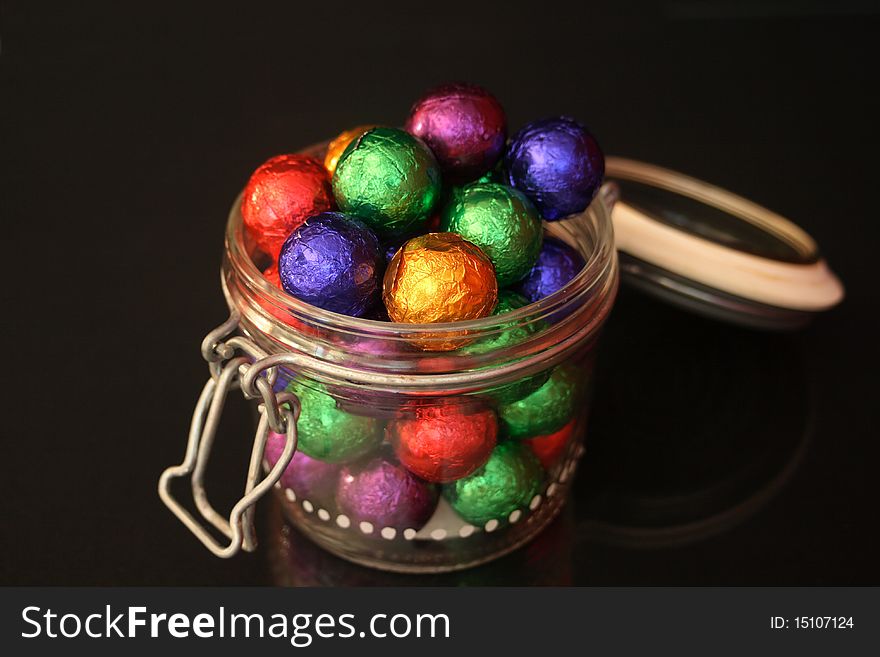 Chocolate balls in a candy jar with black background