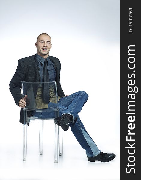 Confident smiling young man sitting in a chair