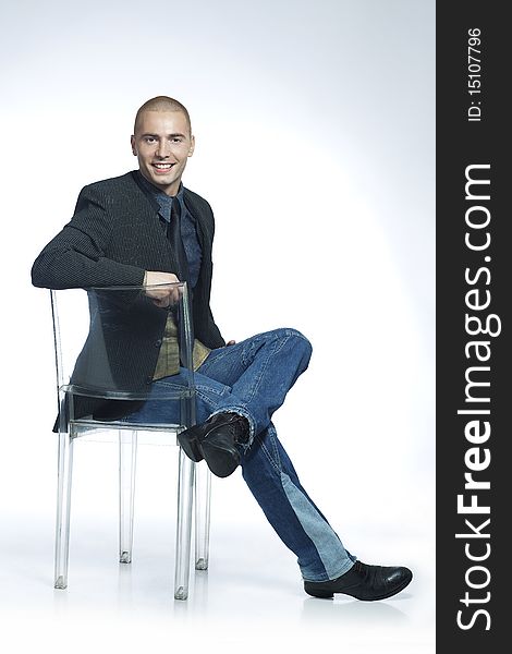 Confident smiling young man sitting in a chair