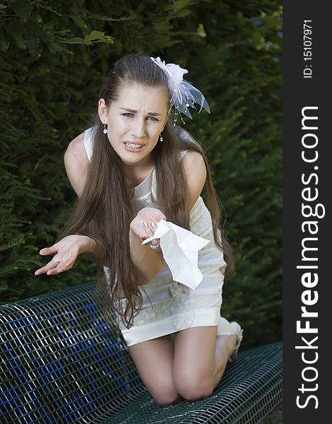 Frustrated bride with handkerchief sitting on the bench