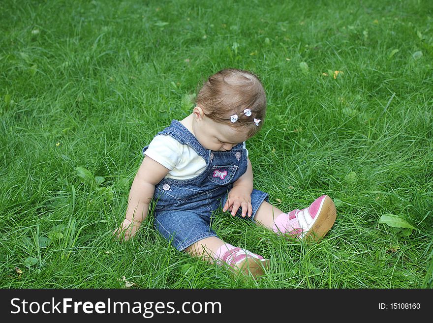 The girl sits on a grass