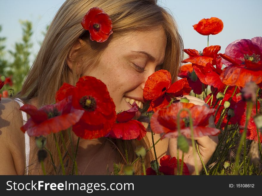 Portrait of a beautiful girl in the red poppies