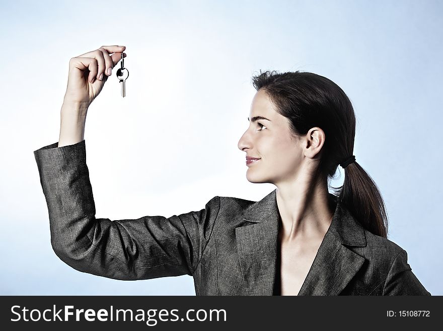 The Key to Success concept: Profile portrait of young business woman holding key between fingers. The Key to Success concept: Profile portrait of young business woman holding key between fingers.