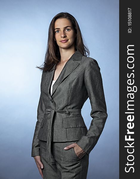 Three-quarter portrait of confident businesswoman in grey suit with arms down looking straight. Three-quarter portrait of confident businesswoman in grey suit with arms down looking straight.