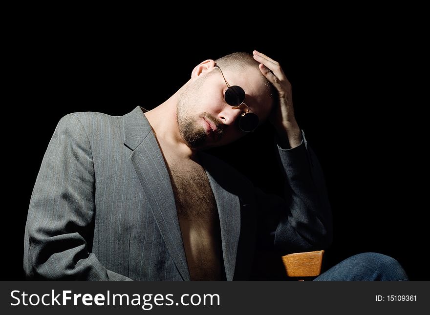 Portrait of bristly man in coat in the dark