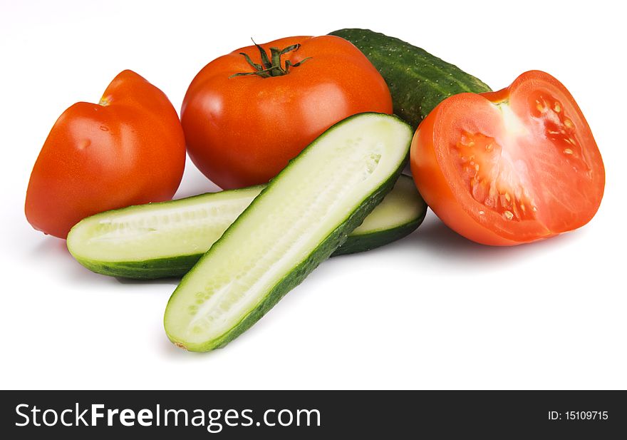 Tomatoes and cucumbers on white background