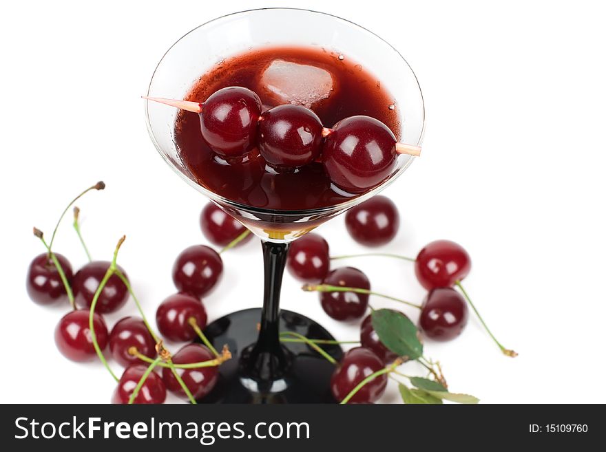 Cocktail with ice and fresh cherries, it is isolated on a white background.