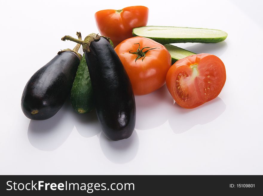 Tomatoes and cucumbers on white background