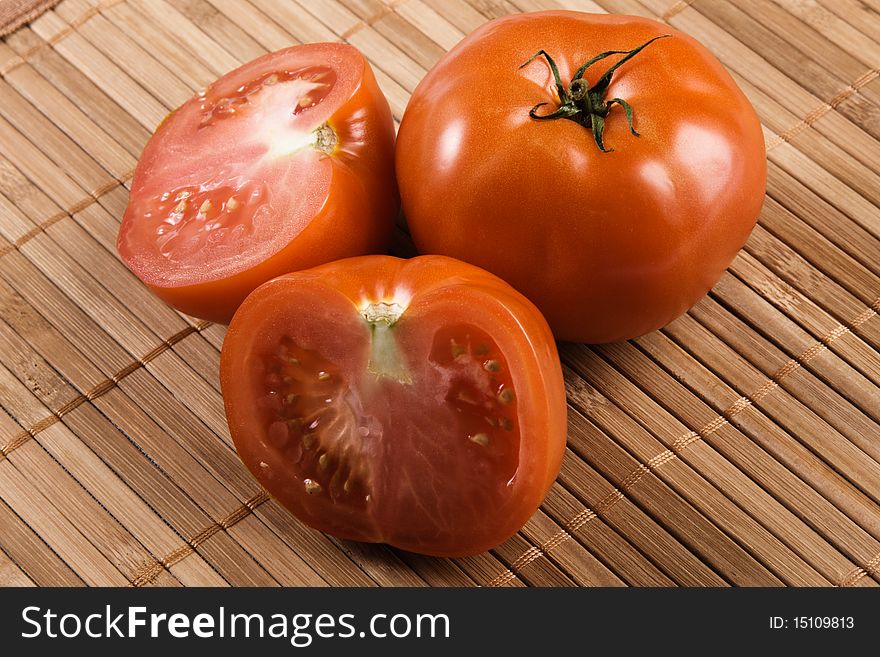 Ripe tomatoes on bamboo pad