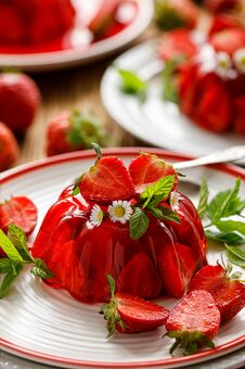 Strawberry Jelly With The Addition Of Halfs Of Fresh Strawberries And Mint Leaves On A White Plate. Stock Images