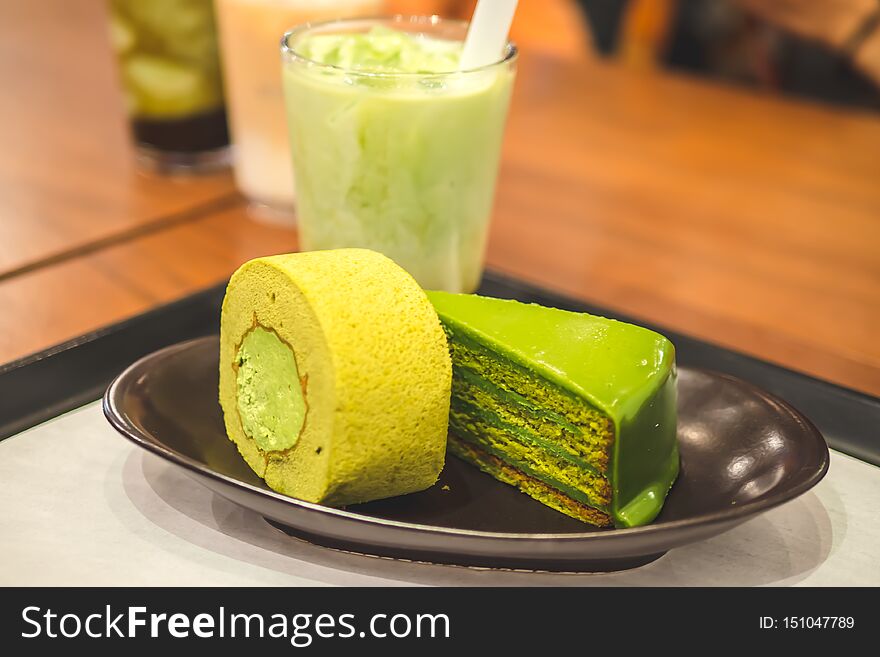 Matcha green tea cake and green tea roll jam on plate, Top view, wooden table.