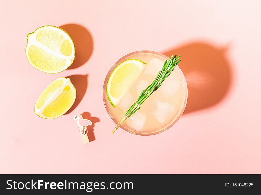 A refreshing drink of lemon and lime lemonade in a transparent glass on a pink pastel background bright sunlight. Summer cocktail or mojito. Top view flat layout. Copy space. Concept minimalism. A refreshing drink of lemon and lime lemonade in a transparent glass on a pink pastel background bright sunlight. Summer cocktail or mojito. Top view flat layout. Copy space. Concept minimalism