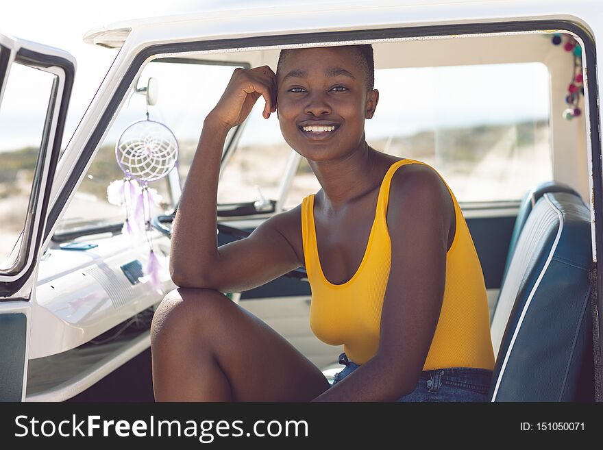 Woman Looking At Camera While Sitting In A Camper Van At Beach