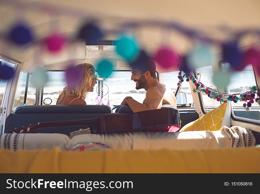 Couple Talking With Each Other In Camper Van At Beach