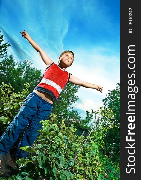 Photo of happy boy who shows his hands against the sky. Photo taken with the use of special effect it