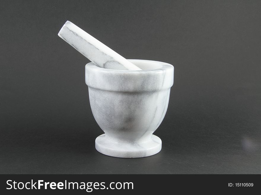 A pharmacist mortar and pestle on a grey background. A pharmacist mortar and pestle on a grey background.