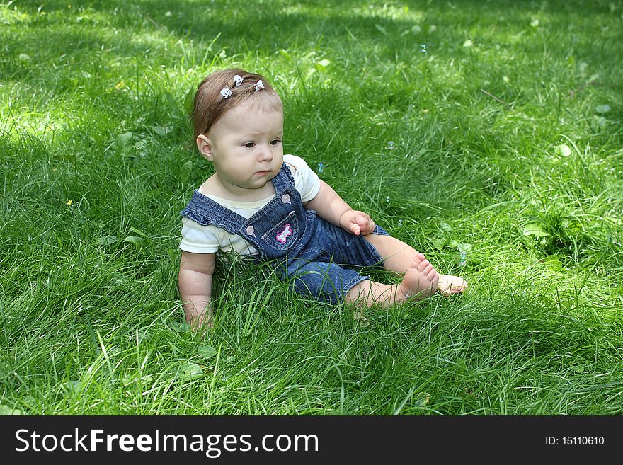 The girl sits on a grass