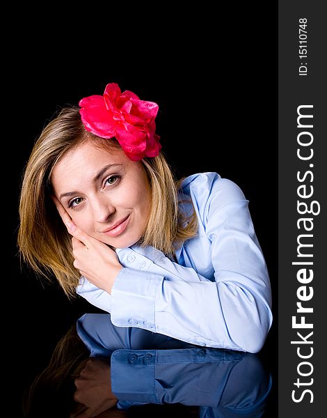 Blissful, serene, paceful female in blue shirt and with flower in her hairs, studio shoot isolated on black. Blissful, serene, paceful female in blue shirt and with flower in her hairs, studio shoot isolated on black