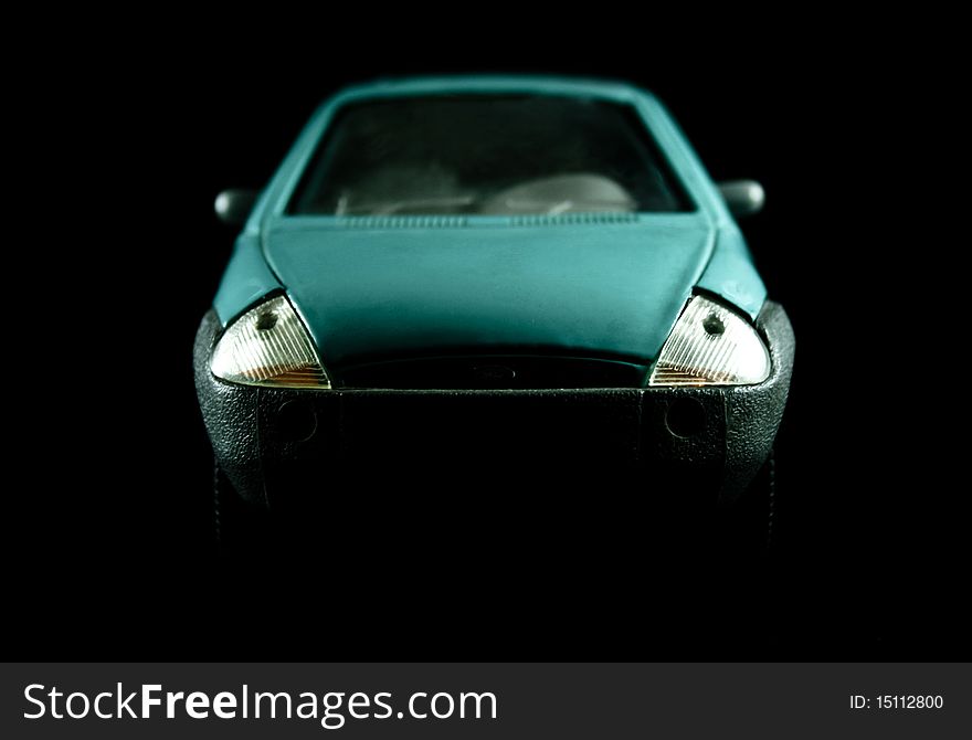 Headlights of a model car, against a dark background