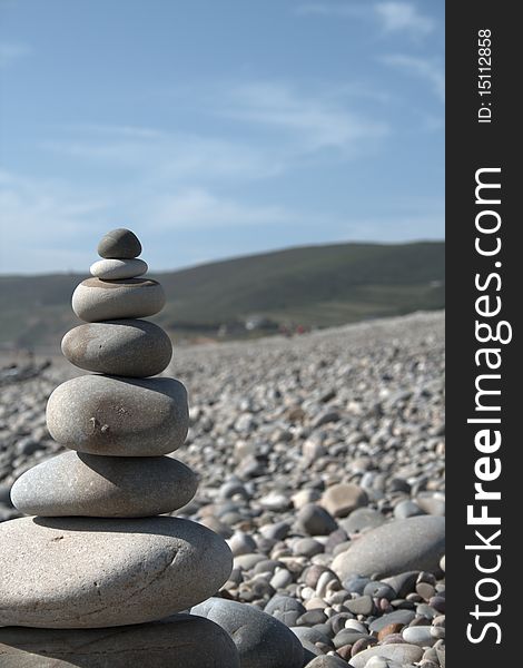 Stone tower on seaside with hilly background and blue sky