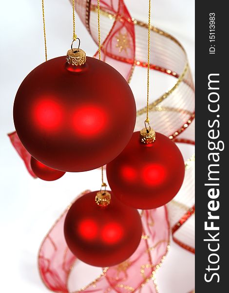 Hanging red glass balls with the ribbon on the white background. Hanging red glass balls with the ribbon on the white background