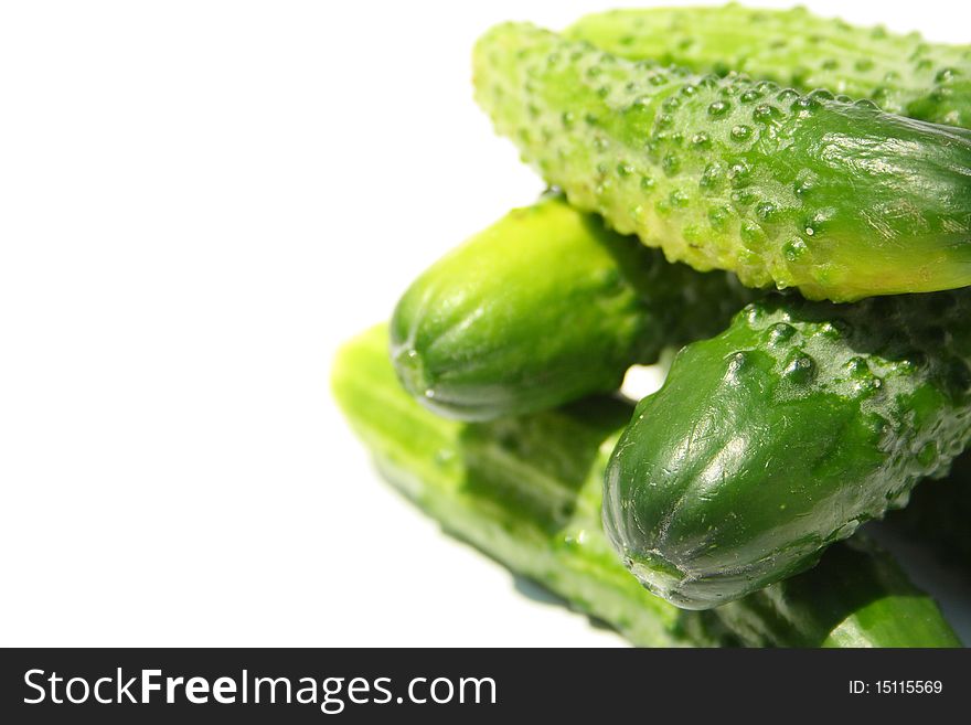 Heap made with cucumbers on a side of image on white background. Heap made with cucumbers on a side of image on white background