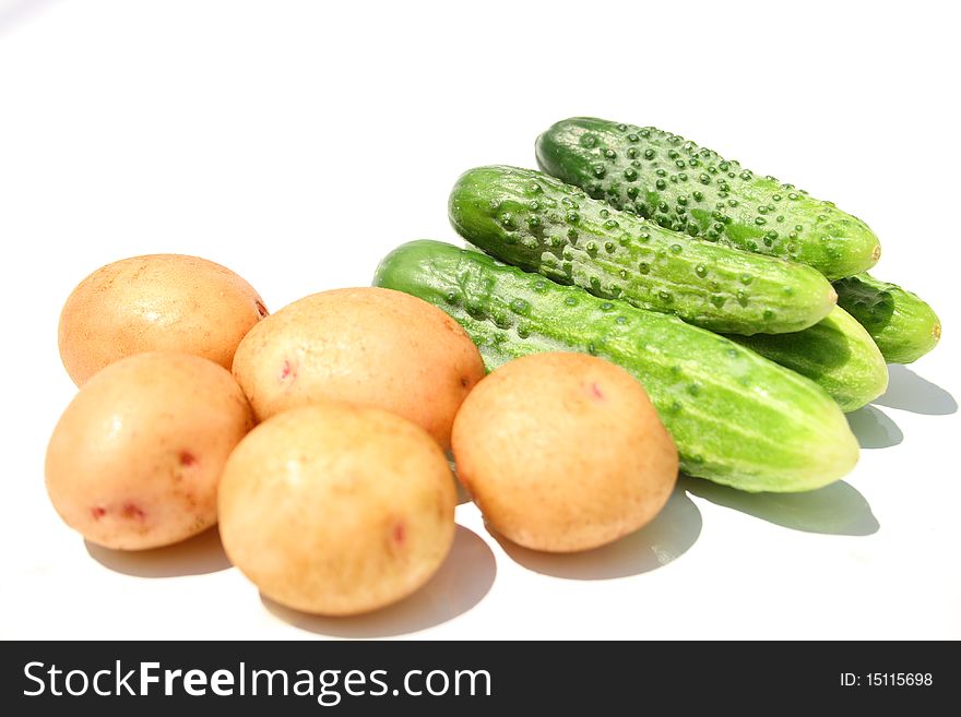 Five potatoes and five cucumbers isolated on white with shadow. Five potatoes and five cucumbers isolated on white with shadow
