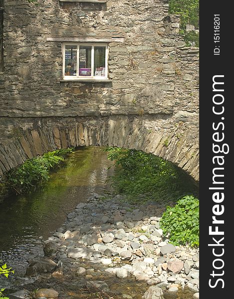 An image of a small stone built house constructed over a river. An image of a small stone built house constructed over a river.