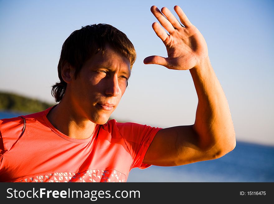 Portrait of  beautiful young men in sports clothing at sunset on the beach. Portrait of  beautiful young men in sports clothing at sunset on the beach