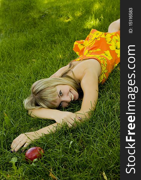 Girl With An Apple On A Green Lawn
