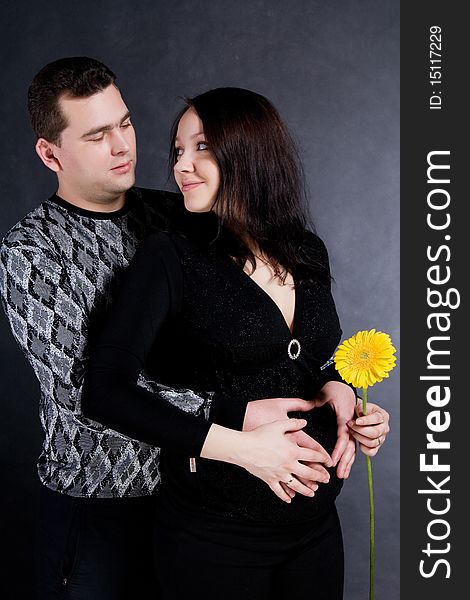 Pregnant couple posing, isolated on dark background. Pregnant couple posing, isolated on dark background