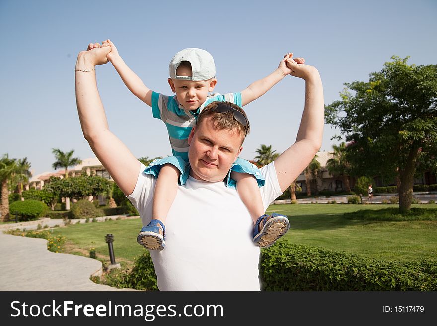 Father with son on shoulders, sunny day. Father with son on shoulders, sunny day