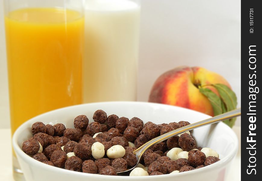 View of the Corn Flakes, chocolate balls, juice and milk,peach. View of the Corn Flakes, chocolate balls, juice and milk,peach