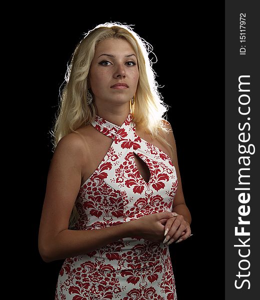 Beautiful blonde young lady in ornamental dress on black background. Beautiful blonde young lady in ornamental dress on black background