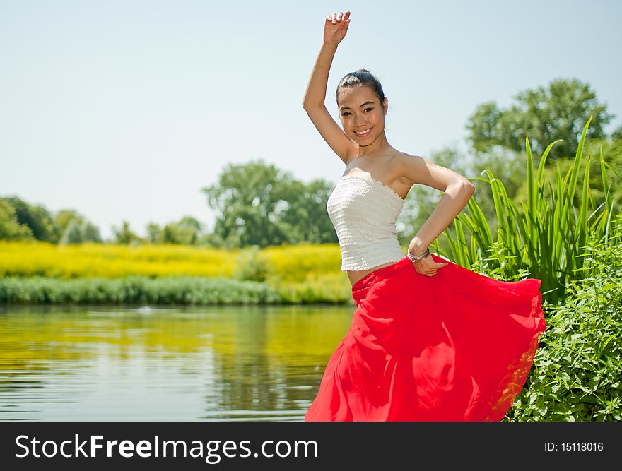 Young Asian woman dancing in the park. Young Asian woman dancing in the park.