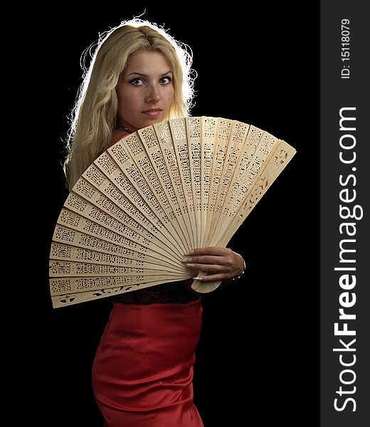 Blonde young lady in red dress with fan on black background. Blonde young lady in red dress with fan on black background