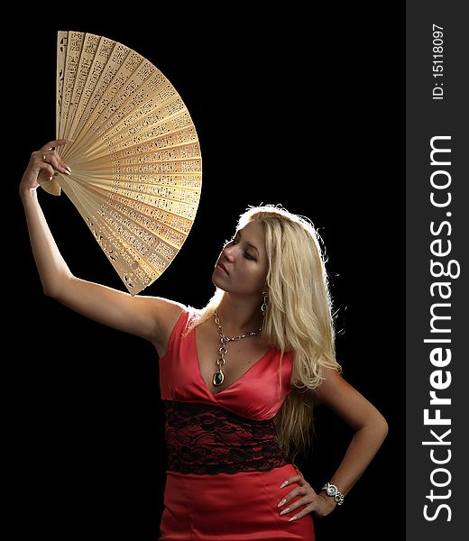 Blonde young lady in red dress with fan on black background. Blonde young lady in red dress with fan on black background