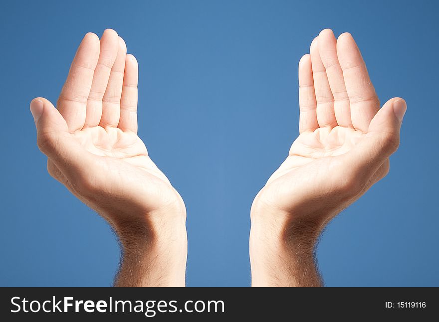 Two open white hands over blue background