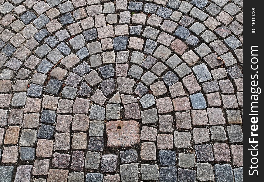 Cobble stone pavement laid out in circular pattern.