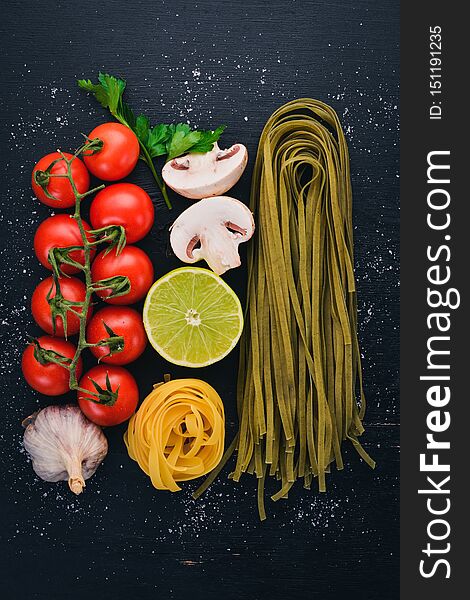 Dry green Pasta with spinach and vegetables On a wooden background. Italian Traditional Cuisine. Top view. Copy space