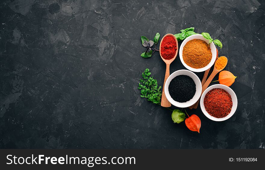 A set of spices and herbs on a stone table. Indian traditional spices. Top view. Free copy space